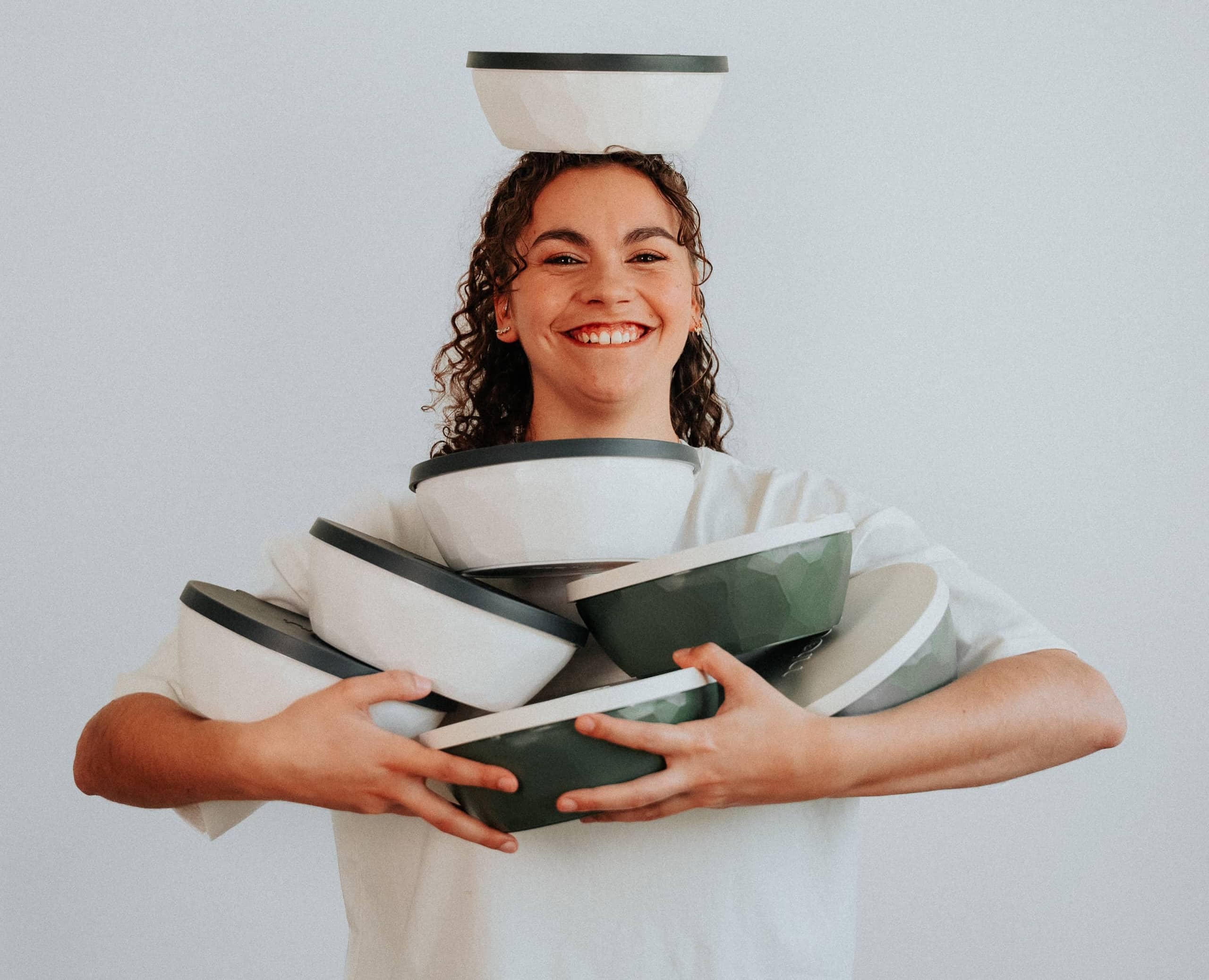 Fille tenant plusieurs bols dans ses mains, reconstituant une montagne de bol.