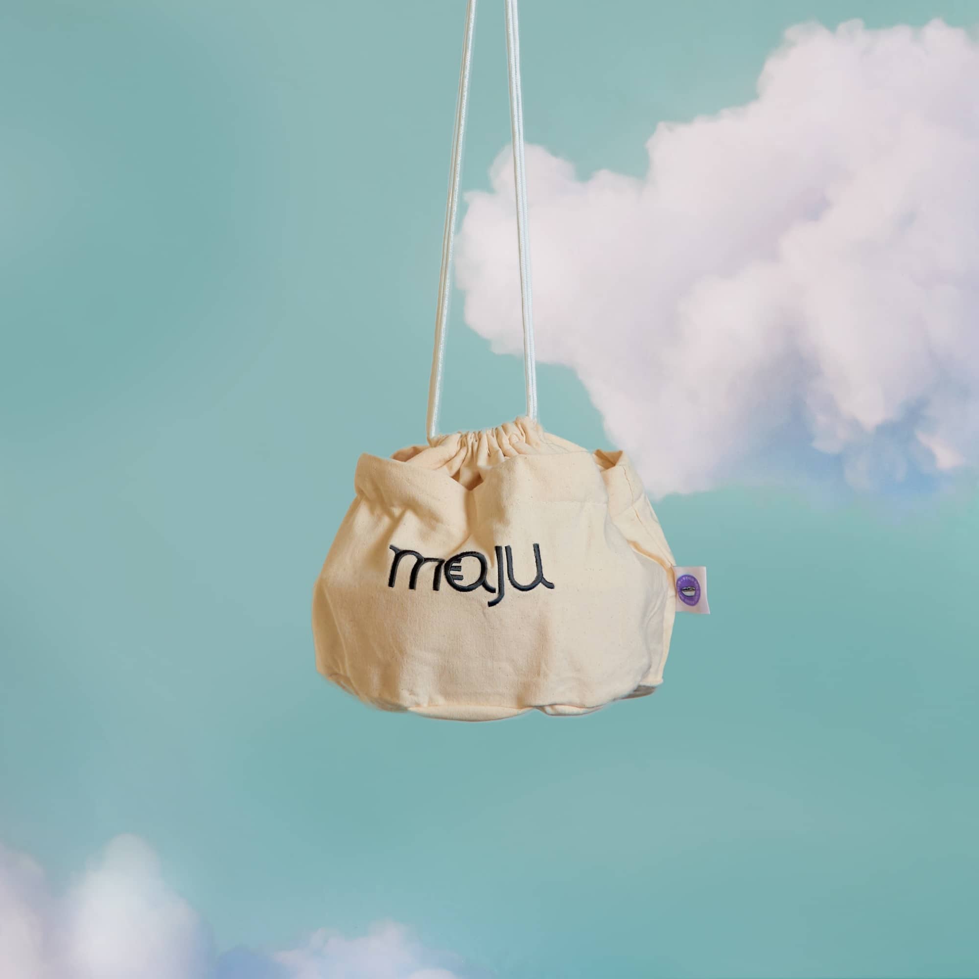 Vue de face du sac de transport maju en coton et de couleur crème.