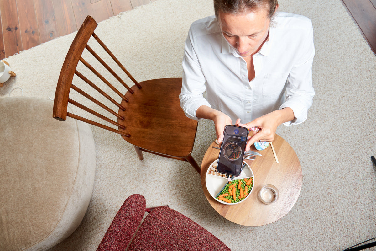 une femme qui prend en photo son bol maju avec l'application maju nutrition